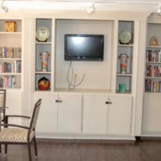 A living room with a built-in bookshelf and television display.