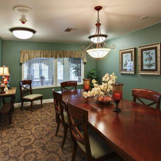 An elegantly designed dining room with a large wooden table, chandelier, and decorative items.