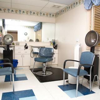 A well-organized hair salon featuring blue chairs, styling stations, and mirrors.