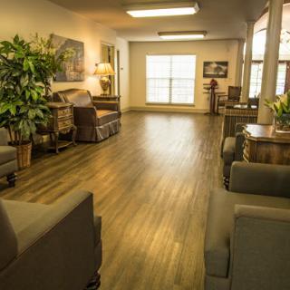 A cozy living room setup featuring comfortable seating, wooden flooring, and natural light coming through the windows.