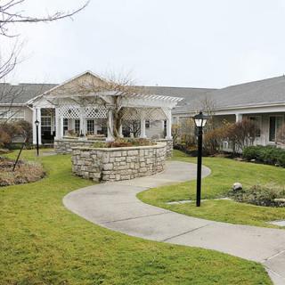 A scenic view of a residential building with a landscaped garden and winding pathway.