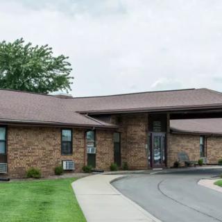A one-story brick building with a driveway and neatly maintained lawn.