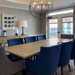 Modern dining room with a wooden table and blue upholstered chairs.