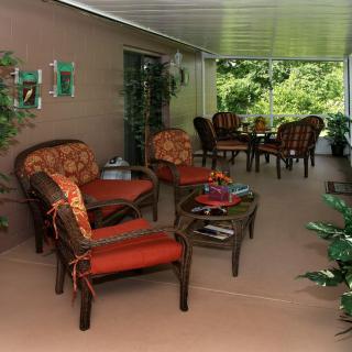 A cozy outdoor patio with comfortable seating and lush garden views.