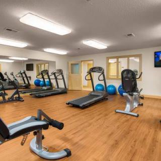 A modern gym with various fitness equipment including treadmills and a stationary bike.