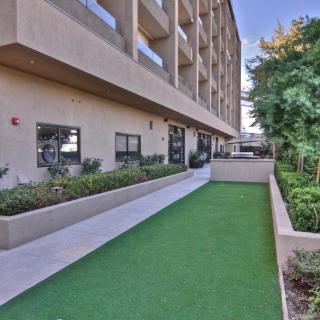 A modern building with well-maintained landscaping and a green lawn area.