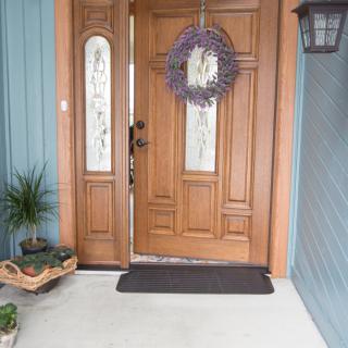 A welcoming entrance with a wooden front door adorned with a wreath.