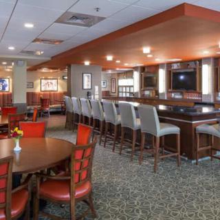 A modern restaurant and bar interior with ample seating and a stylish counter area.