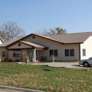 A suburban house with a driveway and a car parked in front.