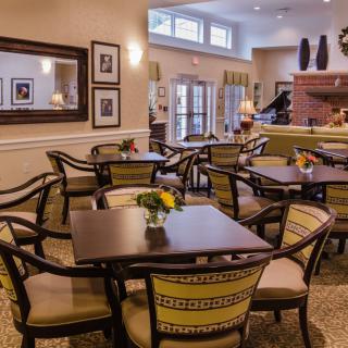 A cozy dining area with neatly arranged tables and chairs, featuring warm interior decor and a welcoming atmosphere.