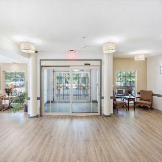 A bright and welcoming lobby with modern decor and a sliding glass entrance.