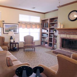 A cozy living room with a fireplace, bookshelves, and comfortable seating.