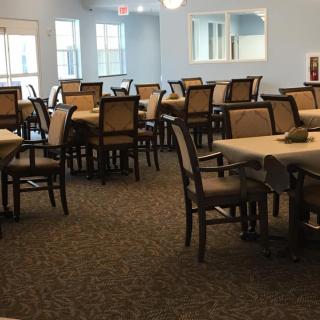 An empty dining room with neatly arranged tables and chairs.