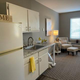 A cozy apartment interior featuring a compact kitchen and living area with modern decor.