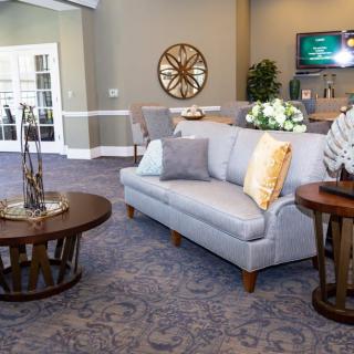 A modern living room with a gray sofa, round wooden coffee table, and elegant decor.