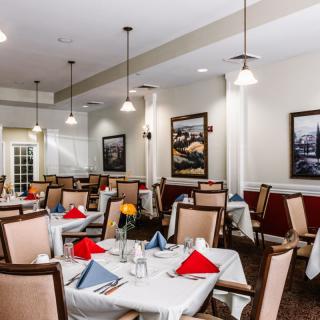 A neatly arranged dining room with tables set and elegant decor.