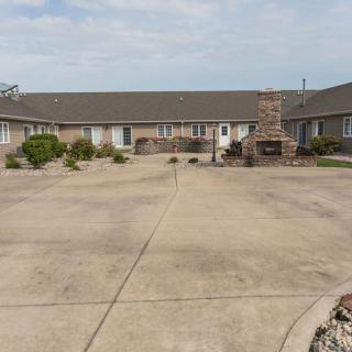 A view of a motel courtyard with surrounding buildings and a central fireplace.
