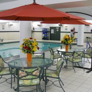 An indoor pool area with tables, chairs, umbrellas, and floral decorations.