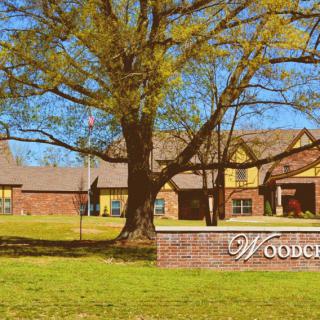 A building with a large tree and a sign that reads 'Woodchase'.
