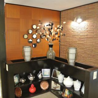 A modern interior corner with decorative vases, shelves, and wall art.