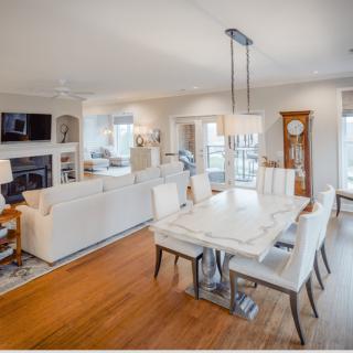 A modern open-concept living room and dining area with elegant furnishings and hardwood floors.