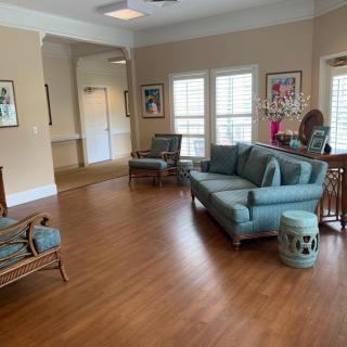 A cozy living room with a sofa, chairs, and artwork on the walls.