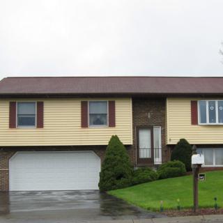 A suburban split-level house with a well-maintained yard.