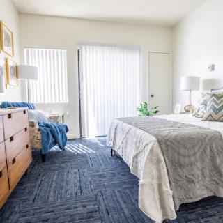 A bright and cozy bedroom featuring modern furniture and soft textures.