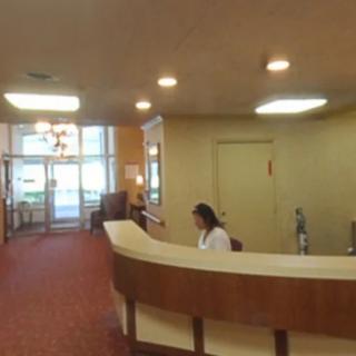 A receptionist working at the front desk in a lobby area.