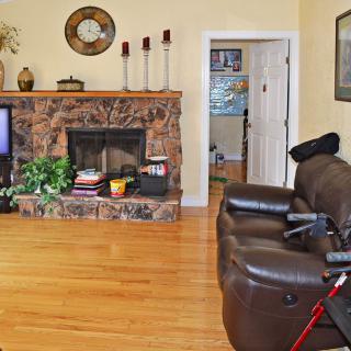 A cozy living room with a fireplace, TV, and accessible seating.