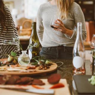 A casual gathering with friends enjoying wine and a charcuterie board in the kitchen.
