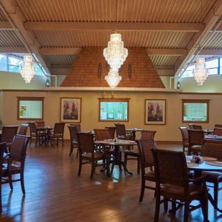 A spacious restaurant interior with elegant chandeliers and wooden decor.