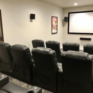 A home theater setup with comfortable seating and a large projector screen.