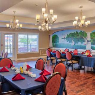 An elegant dining room with chandeliers and a scenic mural.