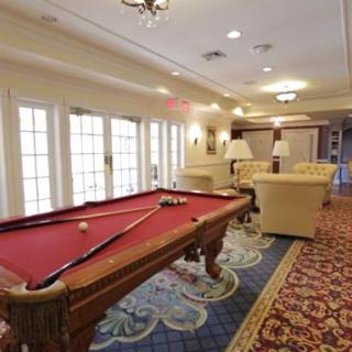 A cozy recreation room featuring a red pool table and comfortable seating.