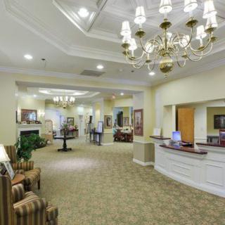 A well-lit reception area with elegant chandeliers and comfortable seating.