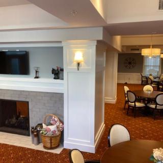 A cozy living room with a fireplace, TV, and a connected dining area.