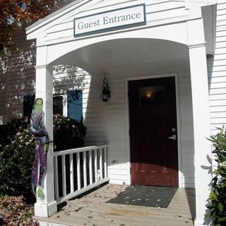 A welcoming guest entrance with a porch and sign.