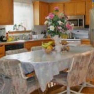 A cozy kitchen with a dining table centerpiece of fresh flowers and fruit.