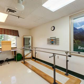 A well-equipped physical therapy room featuring ballet bars for rehabilitation exercises, designed to promote patient recovery.