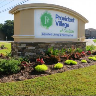 Entrance sign for Provident Village, an assisted living and memory care facility, surrounded by landscaped plants.