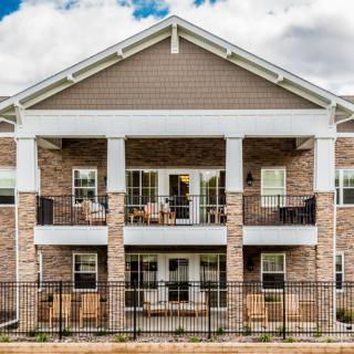 A two-story residential building with brick exterior and balconies.