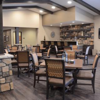 A modern dining area with neatly arranged tables and chairs, featuring contemporary decor.