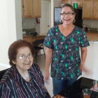 Two people smiling in a kitchen setting.