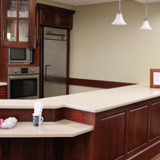 A modern kitchen featuring dark wood cabinets, a countertop, and contemporary appliances.
