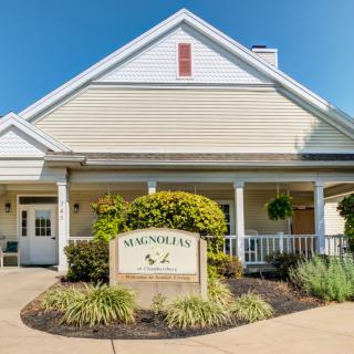 A residential building with a community sign at the entrance, surrounded by well-maintained landscaping.