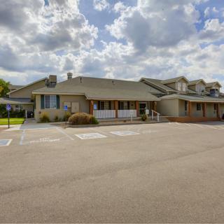 A residential building with an adjacent parking lot under a cloudy sky.