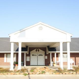 A view of a well-maintained building featuring a prominent front entrance with columns.