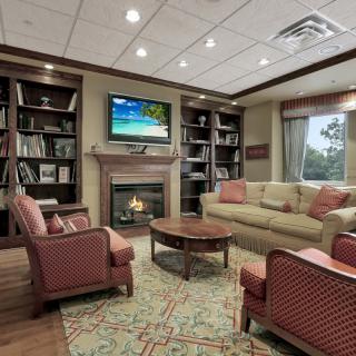 A cozy living room with a fireplace, bookshelves, and comfortable seating.