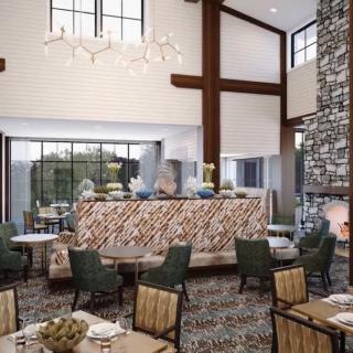 A modern restaurant interior featuring a stylish dining area with elegant furniture and a stone fireplace.
